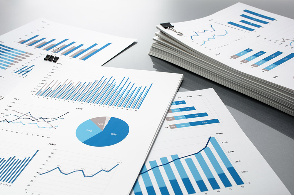 Prepareing report. Blue graphs and charts. Business reports and pile of documents