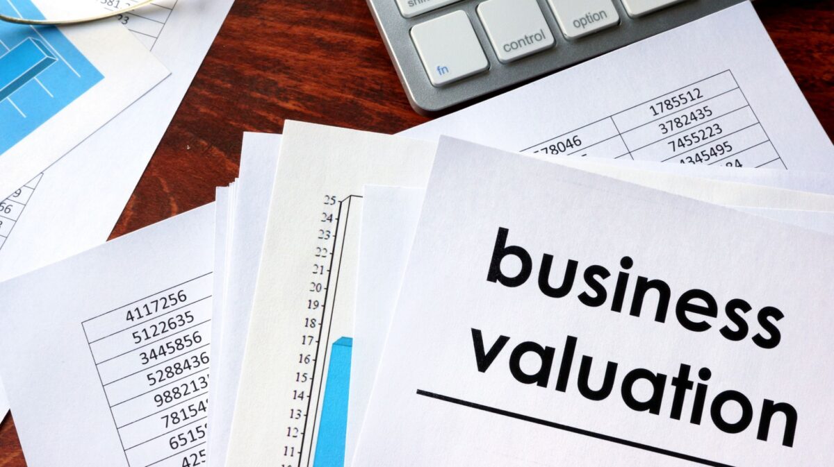 Business valuation report surrounded by financial documents and charts
