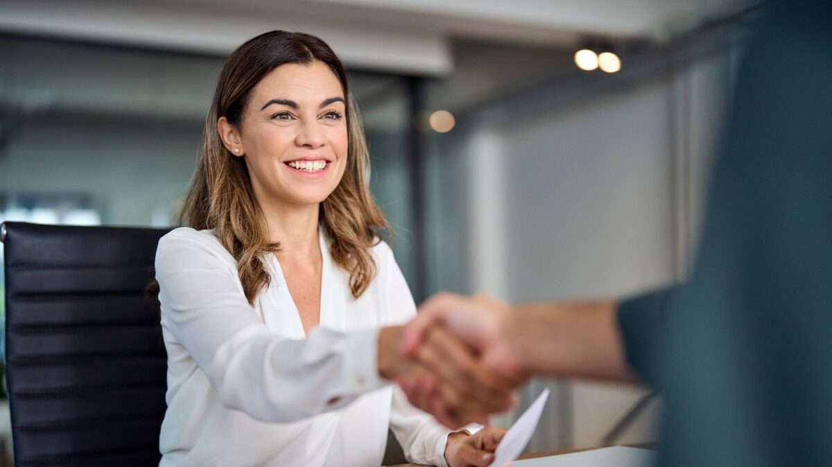 Business ownership transfer agreement with professionals shaking hands